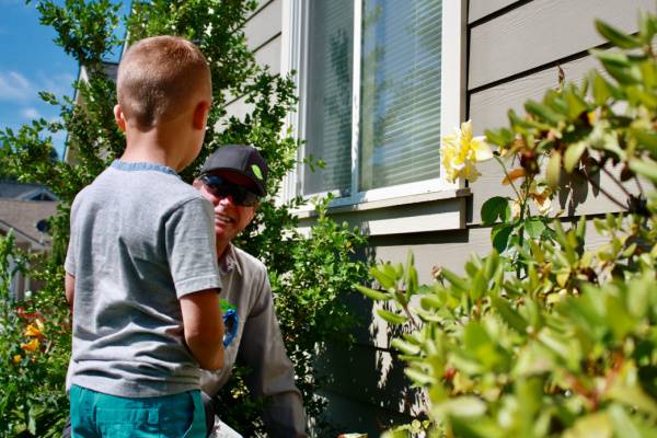 Technician-Explains extermination to boy near house foundation-Columbia SC-Croach Pest Control-600x400